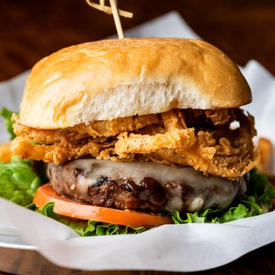 Cheeseburger with crispy onions, BBQ sauce, tomato, lettuce, mustard, and mayo.