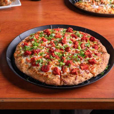 Tandoori Chicken Pizza with bell peppers, onions, tomatoes and tandoori chicken.