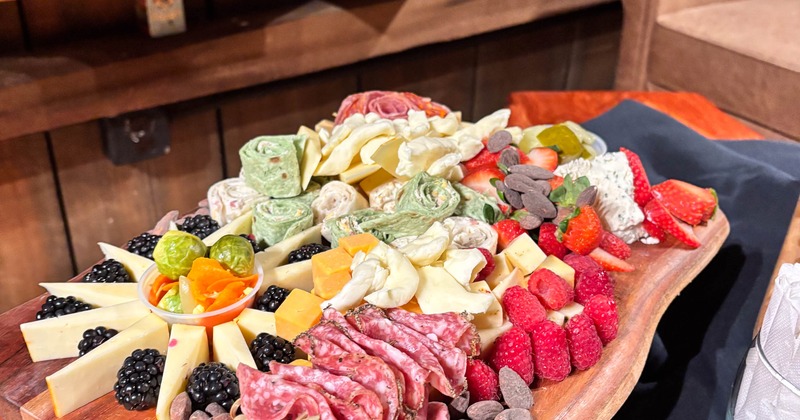 Charcuterie board with assorted meats, cheeses, berries, and nuts