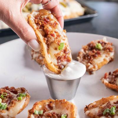 Dipping a potato skin in sour cream.
