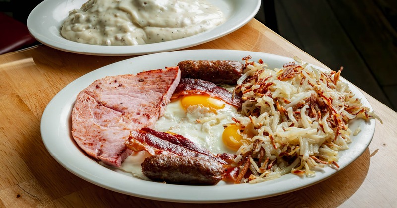 Breakfast plate with eggs, bacon, sausage, ham, and hash browns
