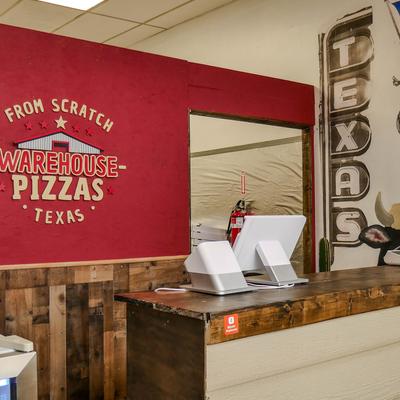 Interior featuring red wall with a restaurant sign and a vintage-style 