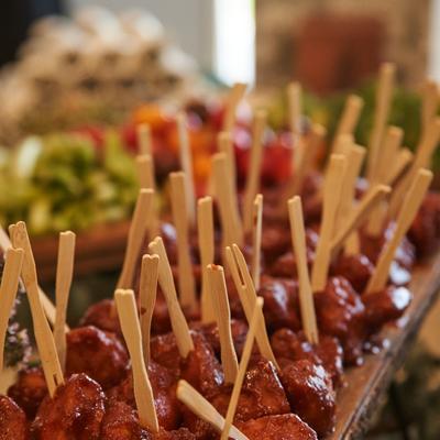 A platter of sauced cocktail meatballs, served as an appetizer.