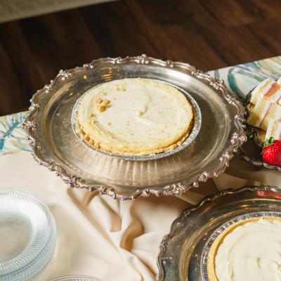 Whole creamy pie resting on a decorative silver-plated platter.