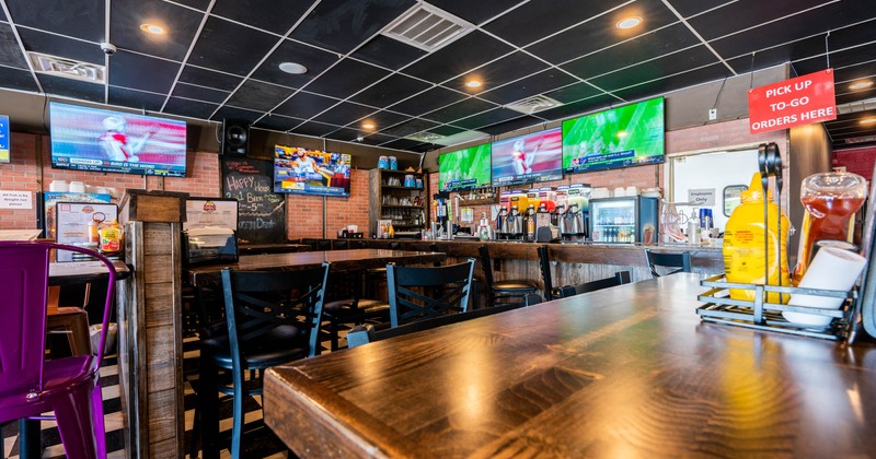 Interior, high seating, bar stools and tables, bar on the right, red brick walls