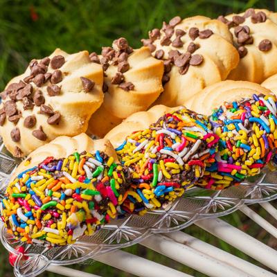 Italian butter cookies with chocolate chips and rainbow sprinkles on a glass tray.