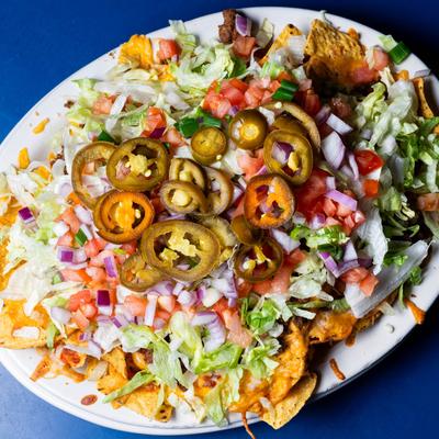 Nachos, with Colby and cheddar cheeses, hot sauce, jalapenos, onion, lettuce, and tomato.