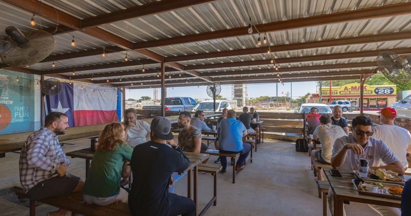 Covered outdoor seating area with guests sitting at tables