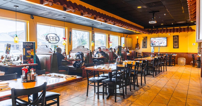Interior, lined up tables in the middle of the room, booths by a window side