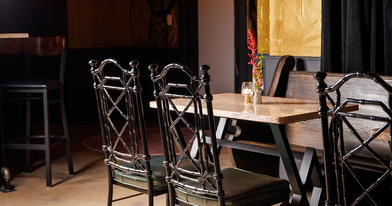 Interior, tables with vintage iron chairs and wooden back bench seating