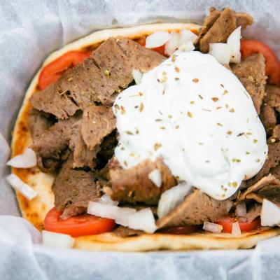 Classic gyro sandwich topped with tzatziki sauce.