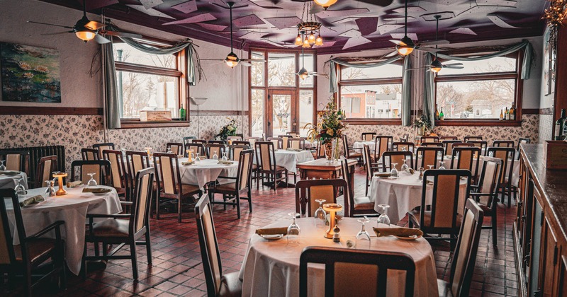 Interior, dining area, white cloth tables for four, six and ten people, tile flooring
