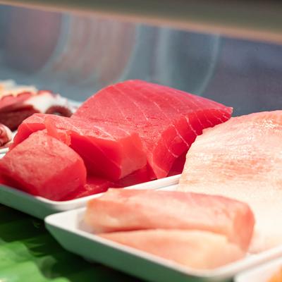 Sushi bar display case, fresh fish pieces.