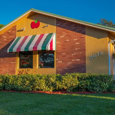Side view at the restaurant's building with a awning in colours of Italian flag.