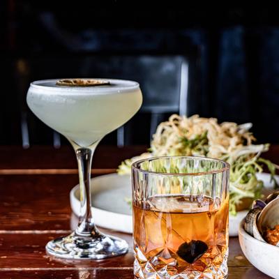 Sage Gimlet and  Old Fashioned, served with salad plates on a table.