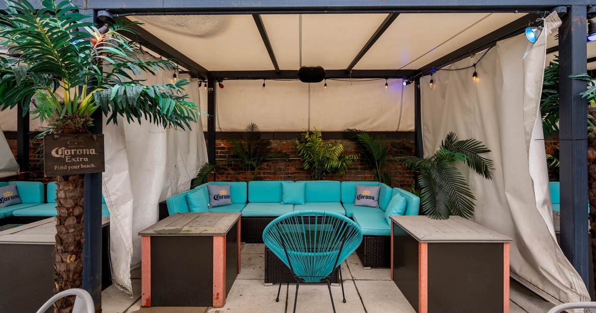 Patio, covered rattan seating with cushion and pillows, chairs and a coffee table