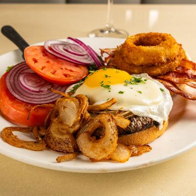 Texas Burger burger topped with a fried egg, bacon, onion rings, tomatoes and red onions.