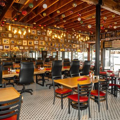 Interior with tables, wall art, and festive decorations on wooden ceiling beams.
