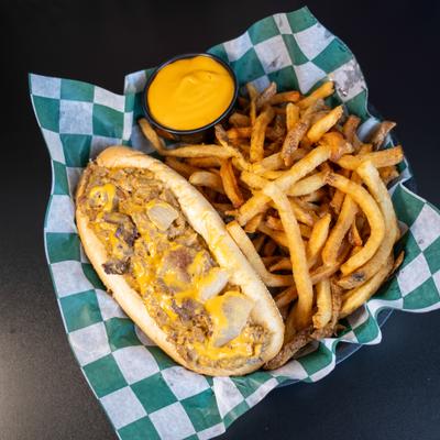 Philly cheesesteak served with fries and a side of cheese sauce.