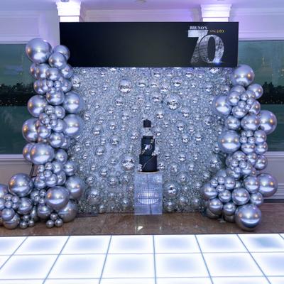 Silver balloon backdrop surrounding sparkling event display.