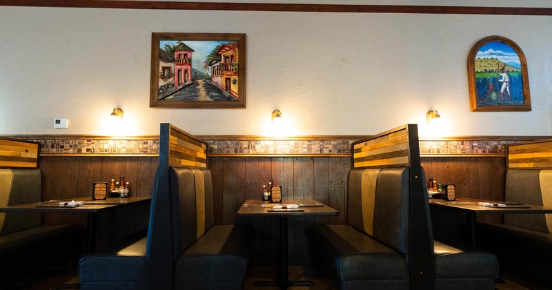 Restaurant booth seating with warm lighting and framed wall art