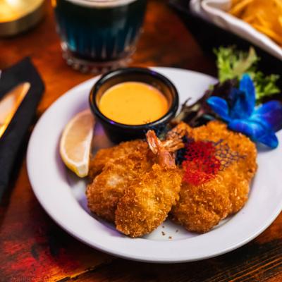 Fried shrimp with sauce, garnished with a blue flower.