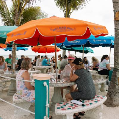 Outdoor seating area, tables under parasols.