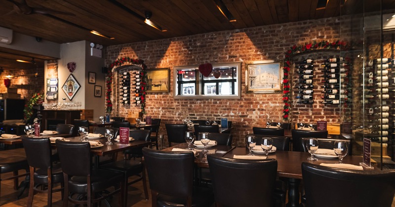 Interior with brick walls, wine racks, and neatly set tables