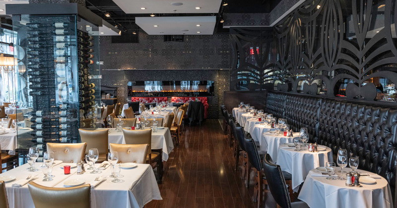 Interior, glass covered wine rack, lined up set tables and seating