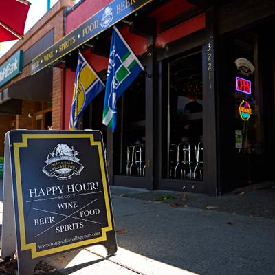 Storefront featuring large windows, blue flags, entrance and a decorative blackboard.