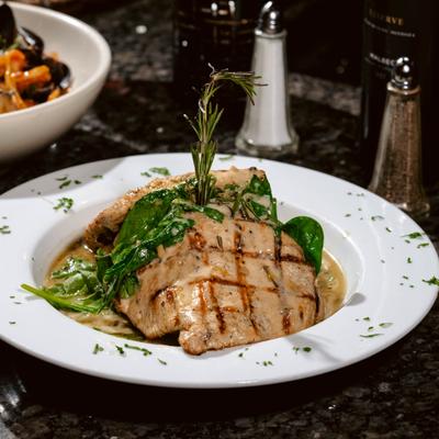 Grilled Chicken Breast served with wilted spinach and garnished with rosemary.