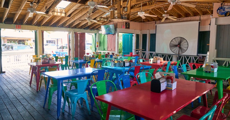 Covered seating area with colorful chairs and tables