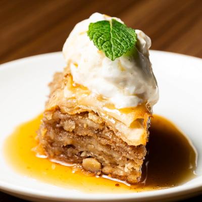 Baklava topped with vanilla ice cream and a mint leaf.