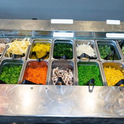 A salad bar featuring a vibrant assortment of fresh vegetables.