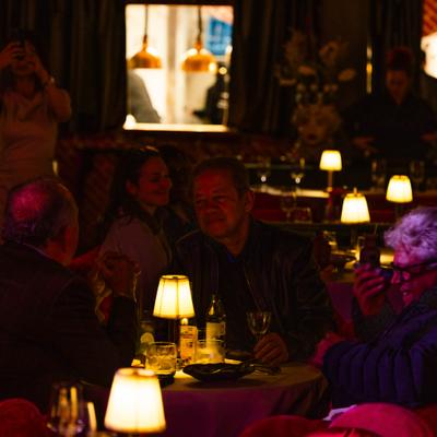 Dining tables set with lamp in low lighting.