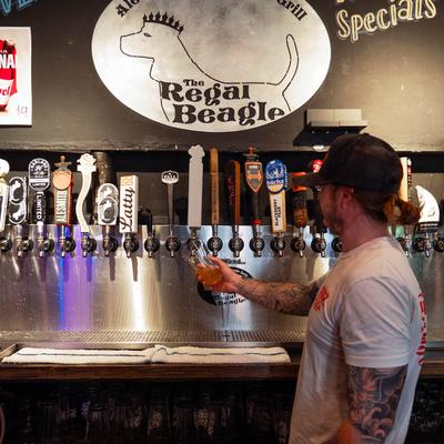 A bartender pouring beer from tap.