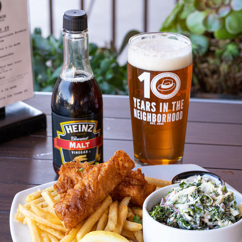 Chicken wings, a bottle of ketchup and a glass of beer