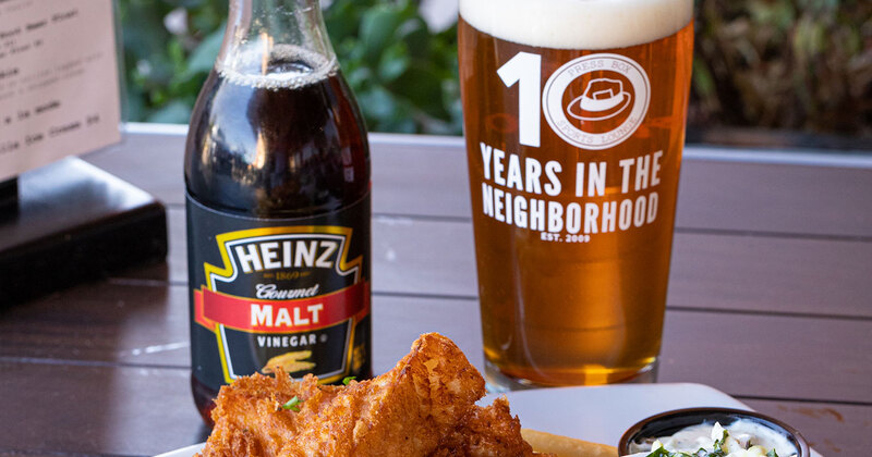 Chicken wings, a bottle of ketchup and a glass of beer