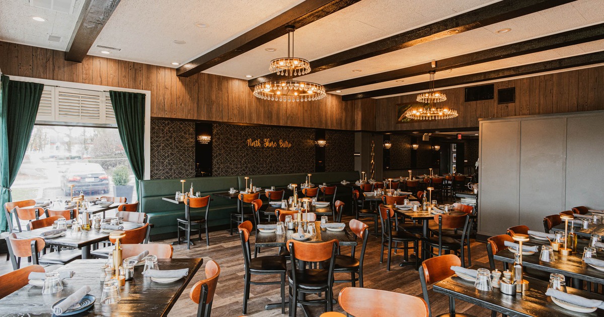 Interior, dining area, wooden top tables for four, banquette bench with tables, chandeliers