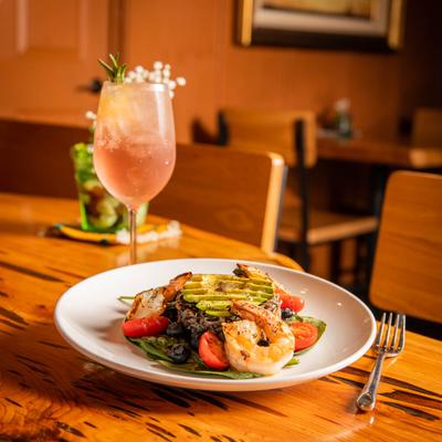 Avocado, wild rice and shrimp salad plate on the table with a glass of cocktail