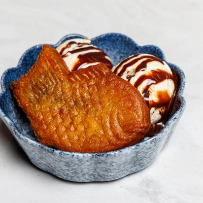Japanese fish-shaped pastry served with vanilla ice cream and chocolate syrup.