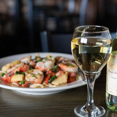 Shrimp Ryan dish served with a glass of white wine.