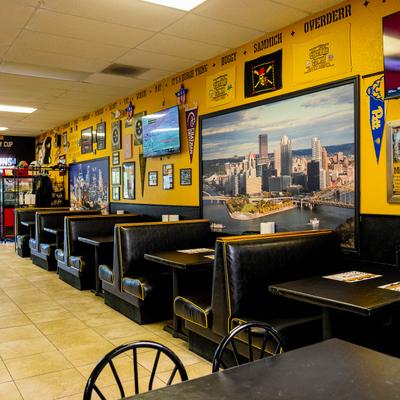 Sports-themed restaurant,  Pittsburgh memorabilia on yellow walls and black booths.