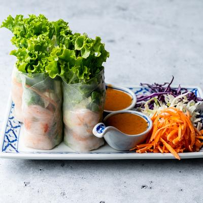Fresh spring rolls with shrimp, lettuce, and peanut sauce on the side.