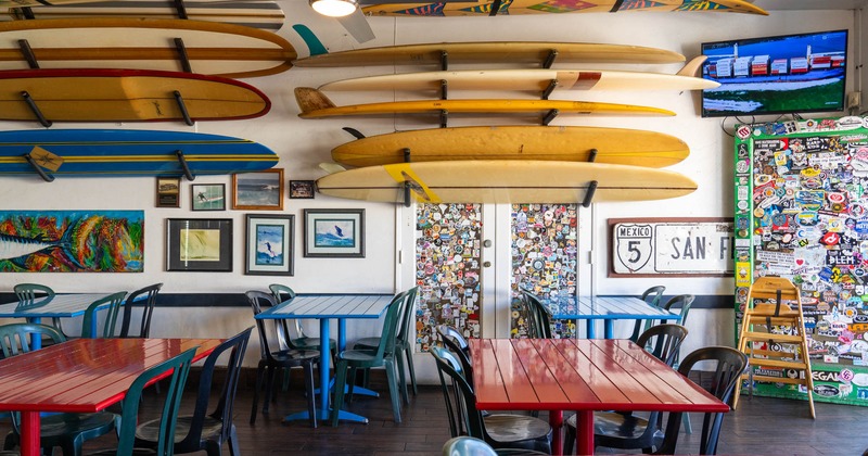 Seating area, wall decorated with paintings and surfboards