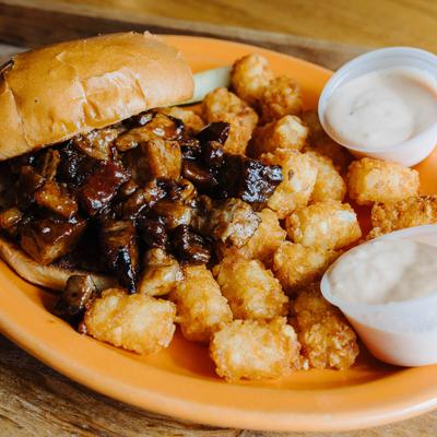 Burnt End Sandwich, with BBQ sauce, and tater tots.