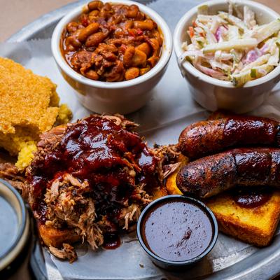 Smoked two meat combo with sides- pulled pork and sausage link over Texas toast.