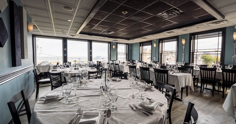 Elegant restaurant dining room with large windows and neatly set tables