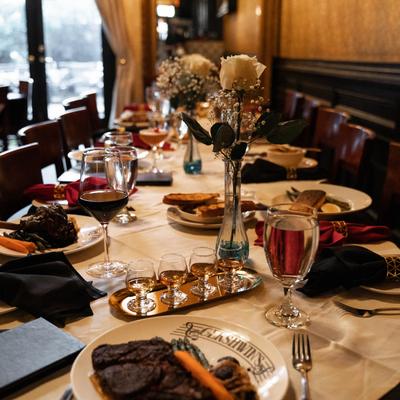 several plated entrees with drinks and bourbon flight.
