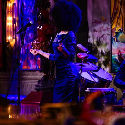 Live performance by singer with colorful paintings behind the stage.